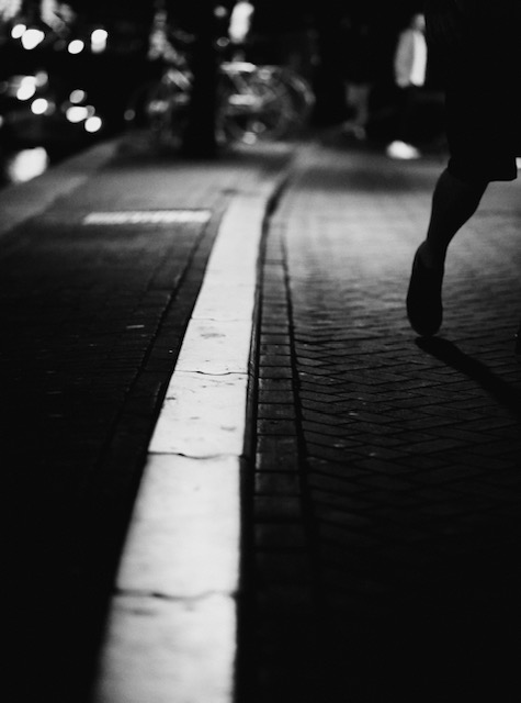 Black and white street curb, with someone walking.